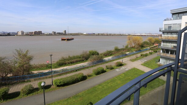 A riverside walkway with a view of the river, a bridge, and buildings in the background. - 2 Beds Riverview HillHouse Apartment (London)