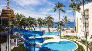 A water park with multiple slides, a pool, and a beach view. - Krystal Vallarta - All Inclusive (Puerto Vallarta)