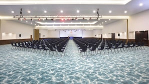 A large conference room with rows of chairs, a stage with lighting, and a screen displaying 'KRYSTAL Puerto Vallarta'. - Krystal Vallarta - All Inclusive (Puerto Vallarta)