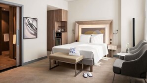 A hotel room with a bed, a bench, a desk, and a chair. - Novotel Bur Dubai (Dubai)