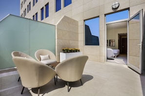 Relax in this stylish outdoor seating area with a comfortable table and chairs, surrounded by a beautiful view.