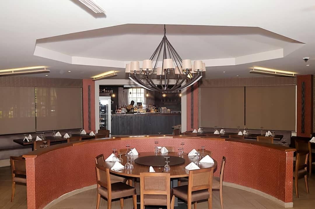 Un comedor moderno con una mesa redonda, sillas y una barra.