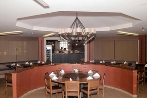 Un comedor moderno con una mesa redonda, sillas y una barra.