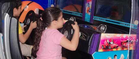 A bus interior with children playing a driving game.