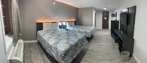 Habitación de hotel con dos camas, un escritorio, un televisor y un radiador.
