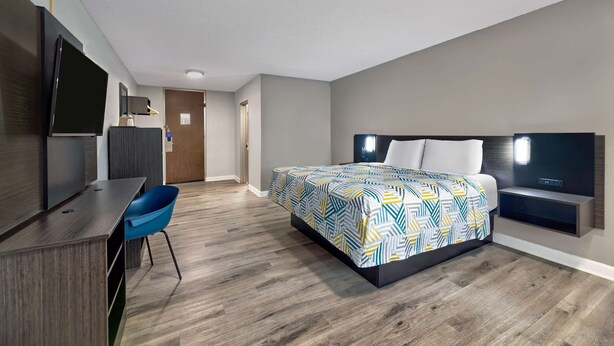 Une chambre d’hôtel moderne équipée d’un grand lit, d’un bureau, d’une chaise et d’une télévision.