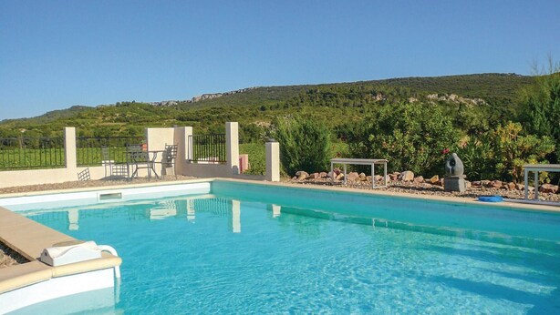 Une piscine d’un bleu éclatant, avec en arrière-plan un paysage vallonné.