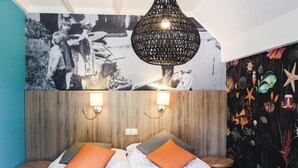 A bedroom with a bed, two wall-mounted lights, a hanging light fixture, and a wall mural. - Awesome home in Ommen with sauna (Ommen)