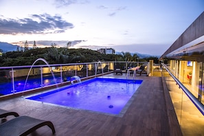 Una piscina al aire libre, sillones reclinables de piscina