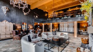 A spacious lobby with a high ceiling, leather sofas, a coffee table, and a chandelier. - Luxury 3 Bedroom Ski in, Ski Out Mountain Vacation Rental Just Steps from the Snowflake Ski Lift (Breckenridge)