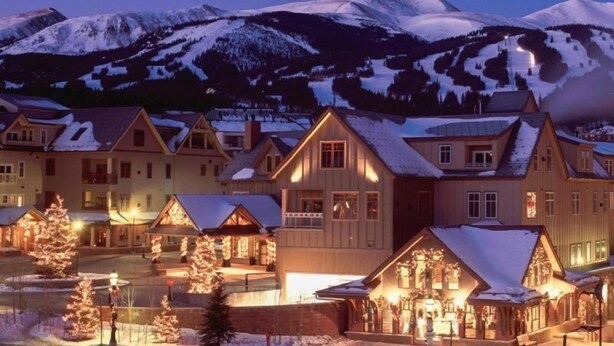 A snow-covered mountain town at dusk with traditional wooden buildings and a central illuminated structure. - Premier 2 Bedroom Mountain View Condo Located in Historic Downtown Breckenridge Walking Distance to Peak 9 (Breckenridge)