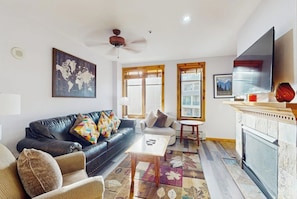 A living room with a sofa, armchair, coffee table, and fireplace. - Premier 2 Bedroom Mountain View Condo Located in Historic Downtown Breckenridge Walking Distance to Peak 9 (Breckenridge)