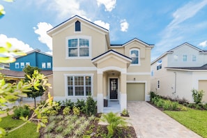 A two-story house with a front porch, a garage, and a landscaped garden.