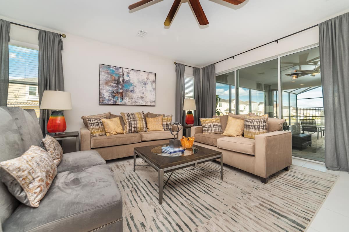 A modern living room with a sectional sofa, a coffee table, and a large window with a view.