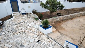 A rooftop patio with a mosaic tile floor, a small tree, and a white planter with blue trim. - Sleep & Go Faro Airport Guest House (Faro)