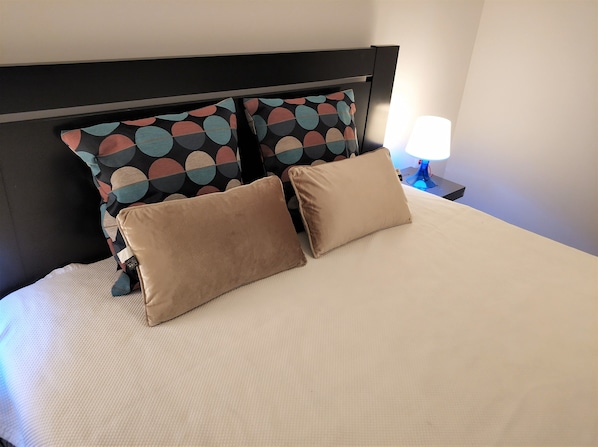 Restful retreat with a neatly made bed and a simple headboard.