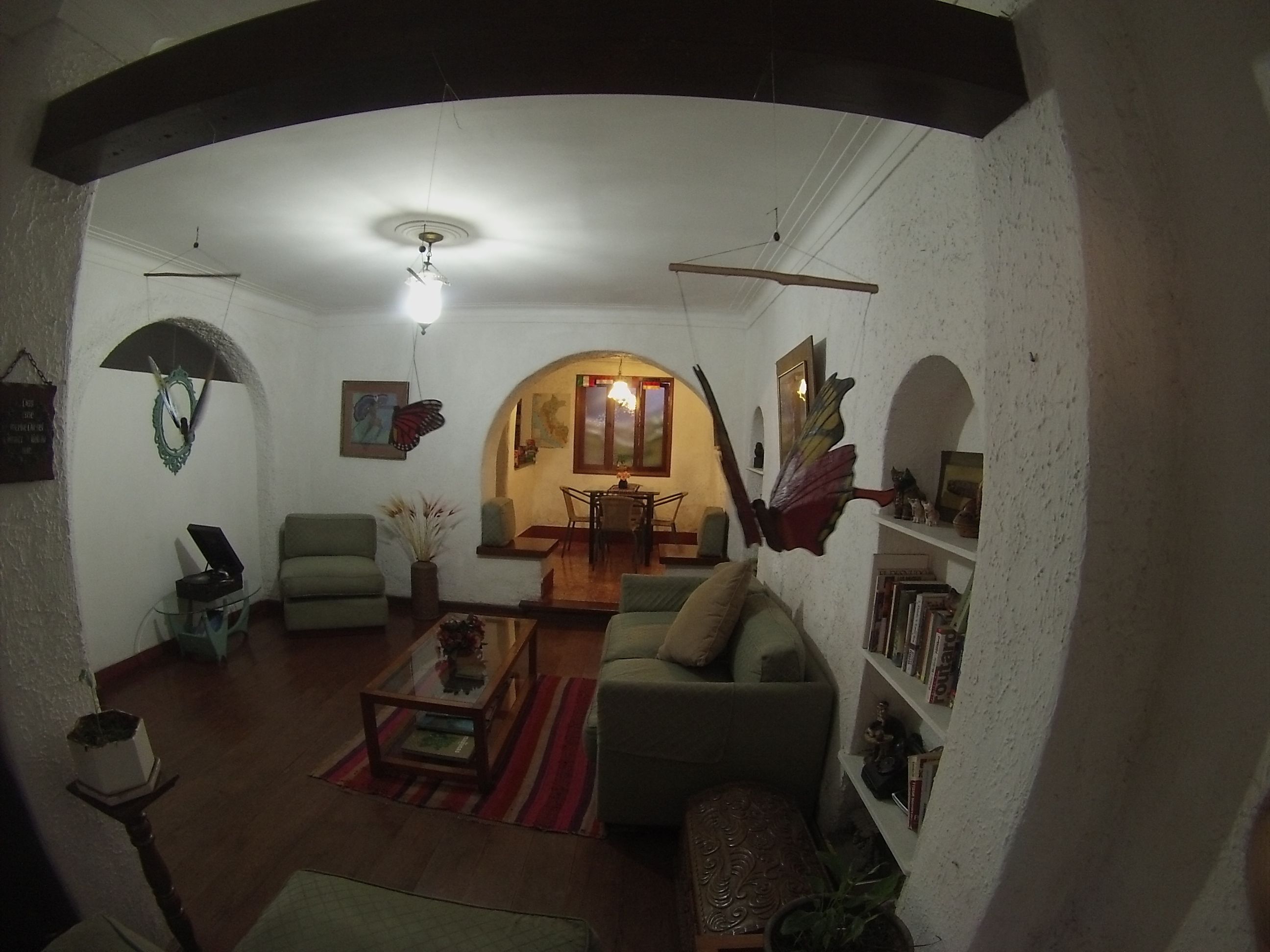 A living room with a sofa, armchairs, a coffee table, and a dining area with a table and chairs.