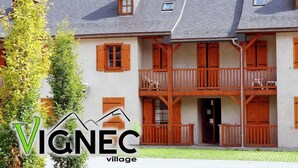Ein zweistöckiges Gebäude mit hölzernen Balkonen und einem geneigten Dach.