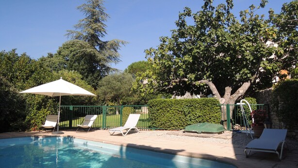 A swimming pool with lounge chairs and a sun umbrella. - 18th century master house with swimming pool (Nages-et-Solorgues)