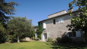 A stone building with a grassy yard and trees. - 18th century master house with swimming pool (Nages-et-Solorgues)