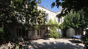 A courtyard with a table and chairs, a barbecue grill, and a ping pong table. - 18th century master house with swimming pool (Nages-et-Solorgues)