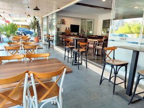 Un restaurant avec une terrasse, des tables et des chaises.
