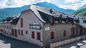 A building with a sign for 'Restaurant L'Authentique' and a 'VIGNEC' sign, surrounded by mountains. - Wifi, 1st floor, swimming pool, balcony, tv, 45m², Saint Lary Soulan (Vignec)
