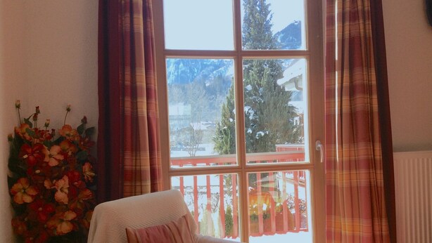 A room with a window, a chair, and a vase of flowers. - Kitz Residenz 6, Kaprun, Zell am See, Salzburg (Kaprun)