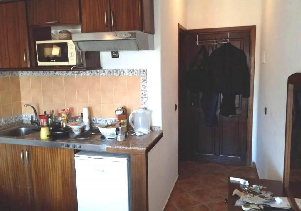 A kitchen with wooden cabinets, a microwave, and a coffee maker.