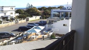 A residential area with modern houses, a parking lot, and a view of the sea. - Studio in Mirador Golf 4119 (Cabo Negro)