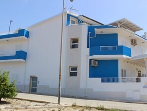 A multi-story building with a white and blue exterior, balconies, and air conditioning units. - Brezza Marina by Interhome (Scicli)