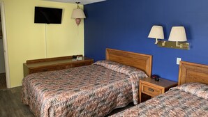 A hotel room with two beds, a TV, bedside lamps, and a wooden nightstand. - Erwin Motel (Painted Post)