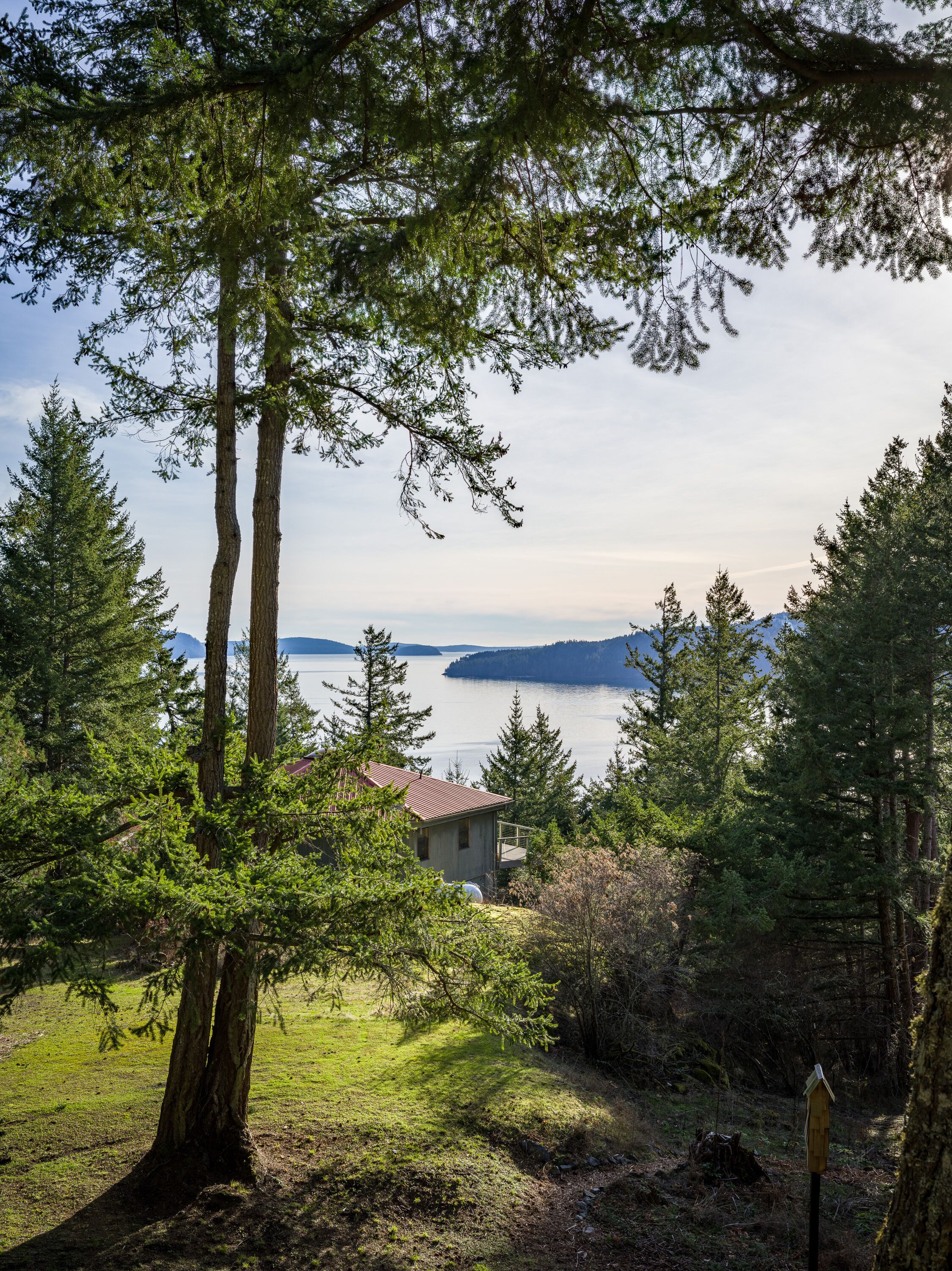A cabin with a view of a lake and mountains.