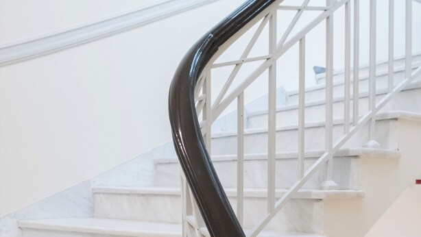A staircase with white marble steps and a black handrail. - Athens Psiri Hotel (Athens)
