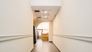 A corridor with a tiled floor, white walls, and a ceiling with recessed lighting. - Athens Psiri Hotel (Athens)