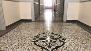 A hallway with a polished granite floor featuring a central decorative pattern. - Athens Psiri Hotel (Athens)