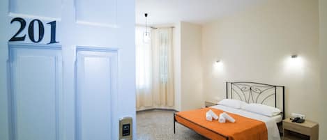 A hotel room with a bed, a nightstand, a phone, and a door with the number 201.