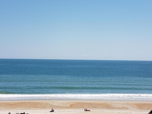 A beach with a clear sky and calm sea. - Oceanfront condo with amazing sunset views 2 bdrm 2 bath condo (Wrightsville Beach)