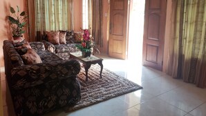 A living room with a patterned sofa, a coffee table, and a potted plant. - I Heart JA Me Lo Dio Dios Ocho Rios (Ocho Rios)