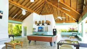 A spacious indoor area with a pool table, a billiards table, and a seating area with a sofa and chairs. - I Heart JA  Coastal DreamVIlla-Richmond Estates (St. Ann's Bay)