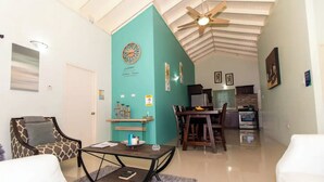 A living room with a sofa, a coffee table, and a dining area with a table and chairs. - Serenity Retreat Villa Drax Hall (Ocho Rios)