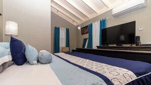 A hotel room with a bed, a flat-screen TV, a desk, and a chair. - Serenity Retreat Villa Drax Hall (Ocho Rios)