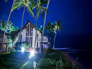 Enjoy a scenic ocean view from the upper-floor balcony of this beachfront property, surrounded by lush landscaping and a beautifully manicured hedge.