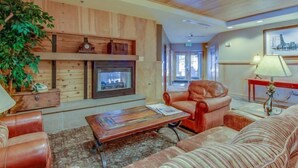 A cozy lobby with a fireplace, leather armchairs, and a patterned rug. - 1 Bedroom Mountain Condo in the Heart of River Run Village within walking distance to ski lift (Keystone)