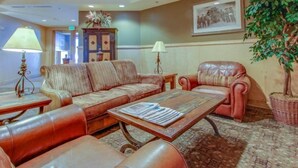 A lobby with a sofa, armchairs, a coffee table with newspapers, a lamp, a cabinet, and a framed picture on the wall. - 1 Bedroom Mountain Condo in the Heart of River Run Village within walking distance to ski lift (Keystone)