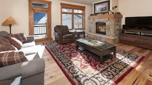A living room with a fireplace, a sofa, a coffee table, and a television. - Premier 2 Bedroom Ski in, Ski out Lone Eagle Condo With the Best Access to Skiing in Keystone (Keystone)