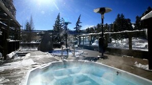 A hot tub surrounded by snow, with a clear sky and trees in the background. - 4 Bedroom Ski in, Ski out Mountain Vacation Rental Located Next to Historic Main Street in Downtown Breckenridge (Breckenridge)