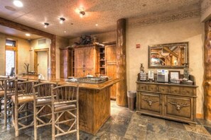 A rustic interior with wooden furniture, a stone floor, and a large wooden cabinet with a mirror. - Premier 2 Bedroom Ski in, Ski out Vacation Rental at the Timbers With the Best Access to Skiing in Keystone (Keystone)
