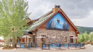 A lodge with a stone facade, wooden exterior, and a large mural of a mountain scene. - 1 Bedroom Premier Mountain Condo in River Run Village Just a Short Walk to Shopping, Dining, and Skiing (Keystone)
