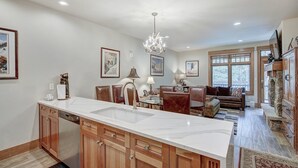 Una cocina amplia con una isla grande, armarios de madera y un candelabro.